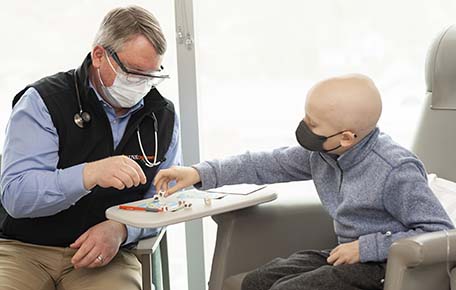 child with cancer plays game with doctor