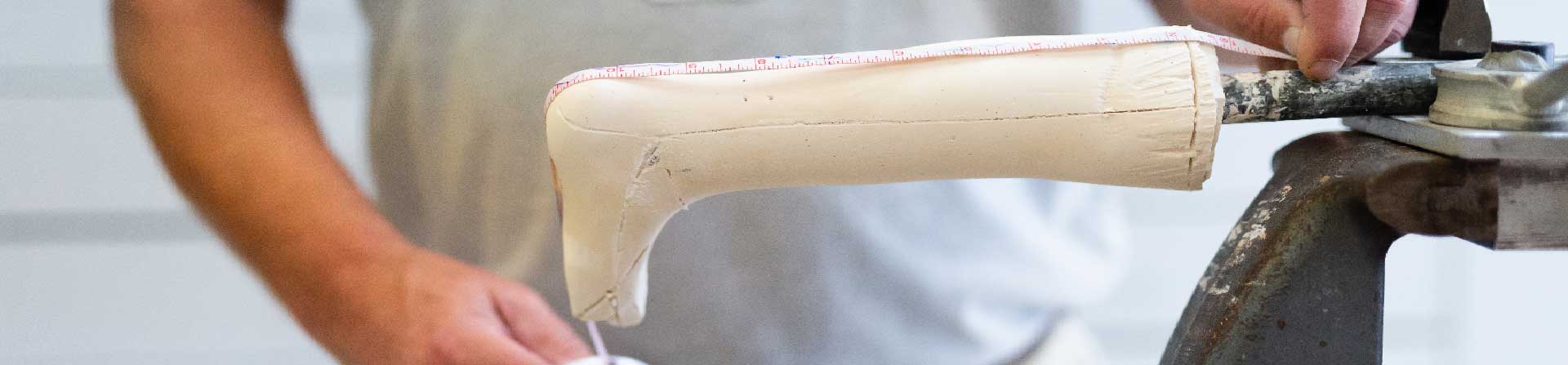 A prosthetics specialist measuring a mold for a child's prosthetic leg.